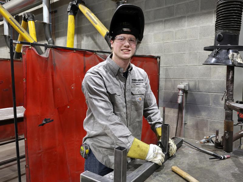 student takes a break in the welding lab