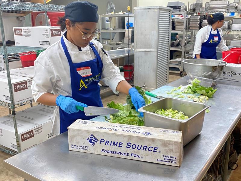 An Alfred State student prepares a meal in a kitchen