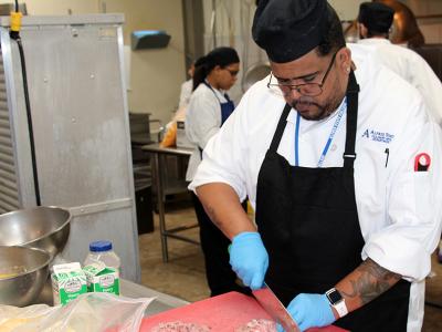 student cutting meat