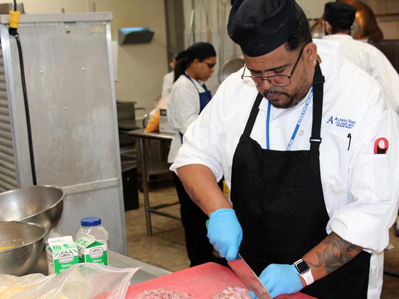 student cutting meat