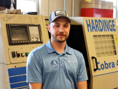 Student stands in front of machinery