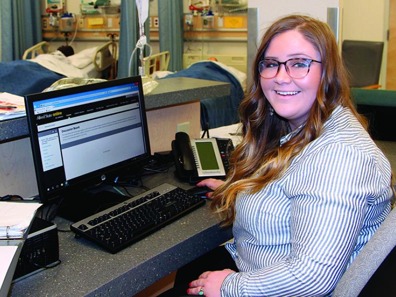student sitting at a computer in a healthcare facility