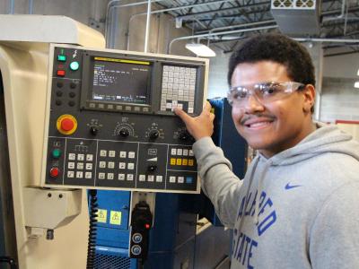 student works on a CNC machine