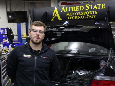 Student stands near sports car