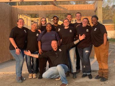 Students pose at the worksite of a Habitat for Humanity house