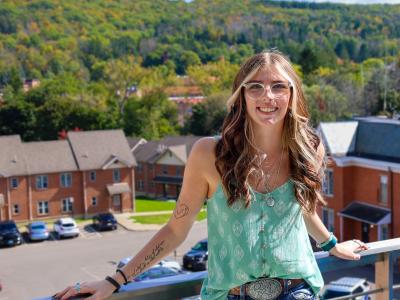 student standing on a balcony overlooking the valley