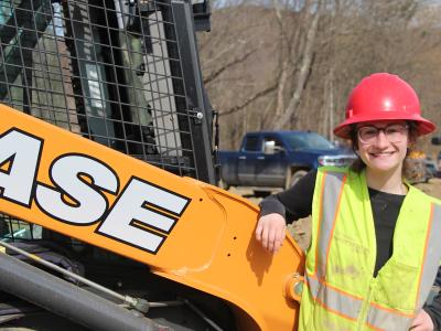 student stands near heavy equipment