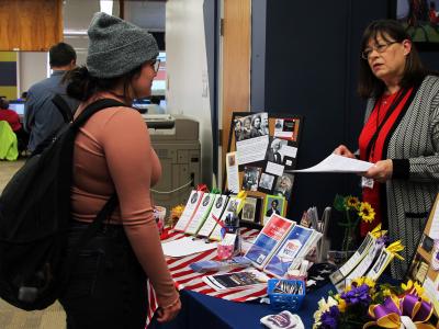 A student speaks with a League of Women Voters representative