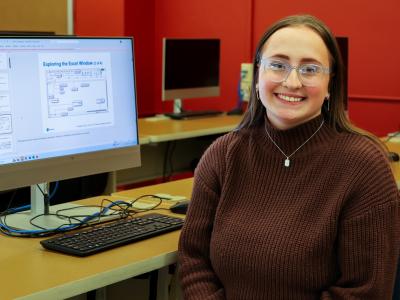 Smiling student in front of her computer