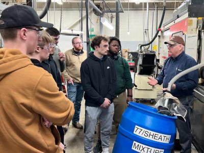 students listen to ASC alum Paul Majot during a visit to KA-Bar