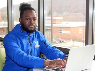 students sitting behind a laptop in a dorm lounge