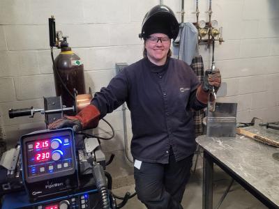 Alfred State welding student Delaney Nichols stands outside her booth. Nichols was named a winner of the Vanguard Award. She is the first Northland student to receive this honor.