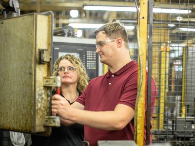 A student and an instructor work in a lab