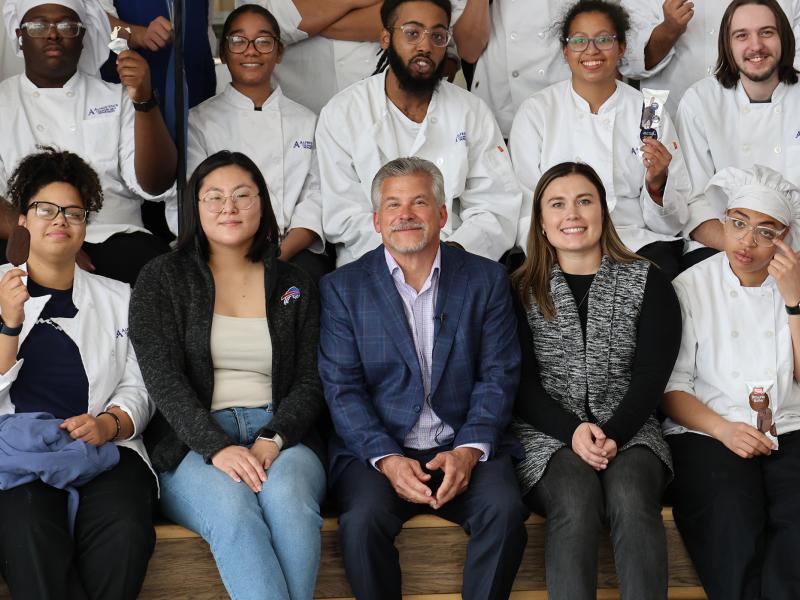 Students pose with an alum