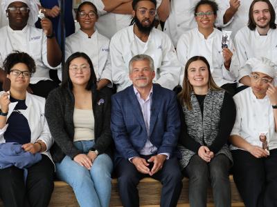 Students pose with an alum