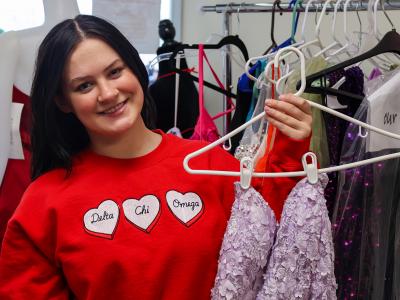 student holds a dress