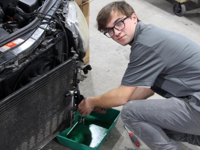 Autobody student Mikal Smith works on a wrecked car in the autobody shop at Alfred State College.