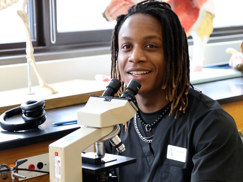 student works with a microscope