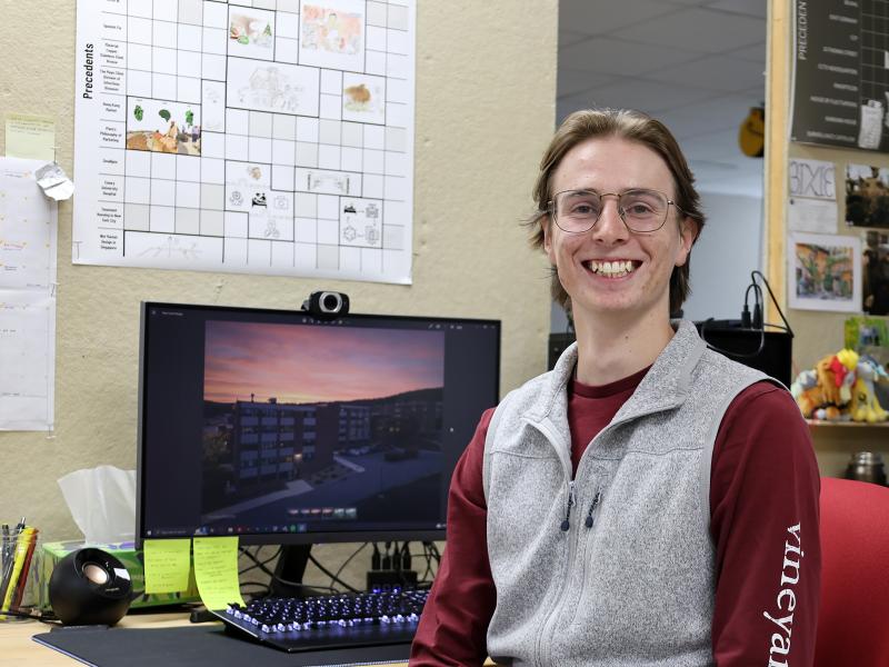 student sits at his desk in front of his architecture projects