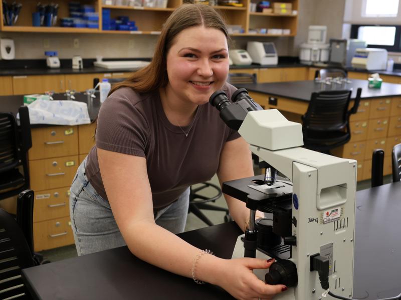 student looking through a microscope