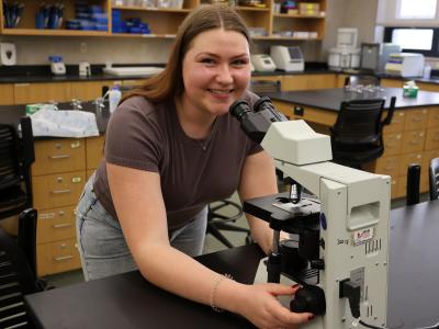 student looking through a microscope