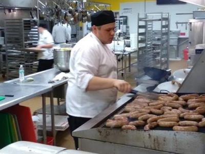 A culinary arts students works on the grill