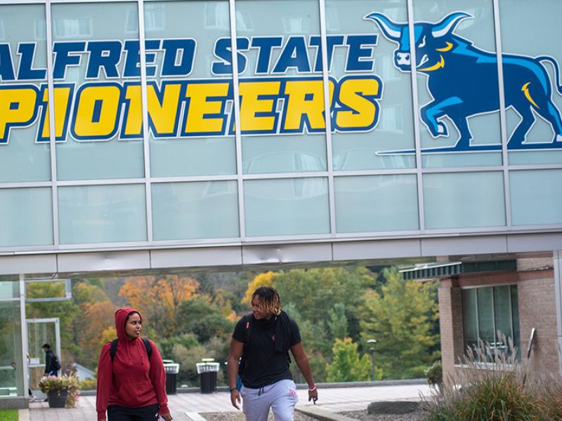 students walking on campus near the Student Leadership Center bridge