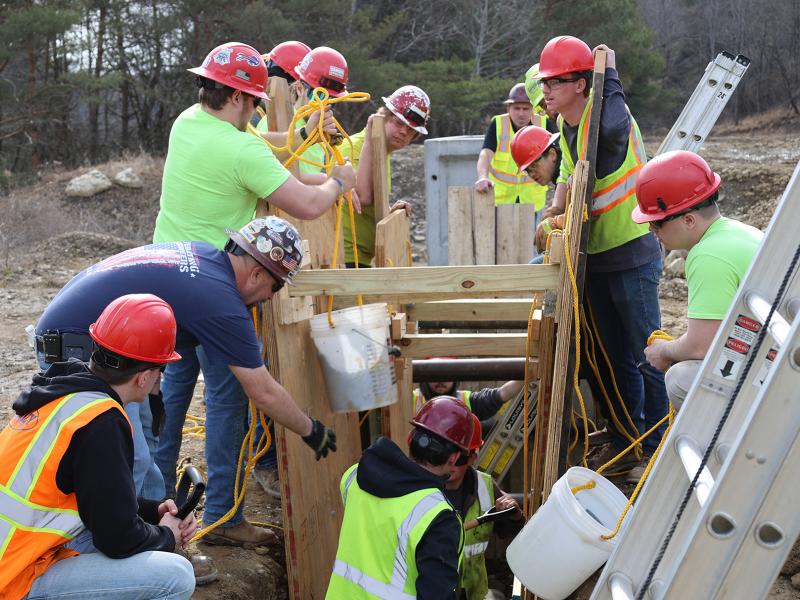 students work on a trench collapse simulation