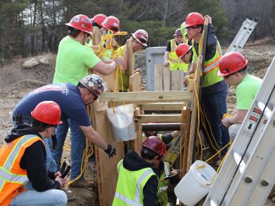 students work on a trench collapse simulation
