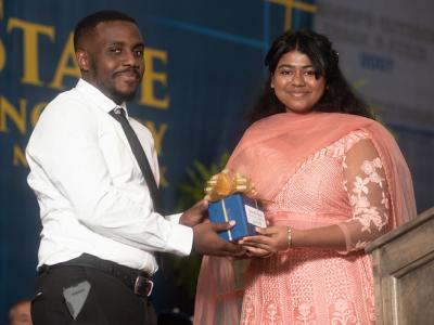 Tyler Richards, the Residence Hall Director in Braddon Hall, receives the Alfred State Student Advocate Award from Student Senate President Soumya Konar.