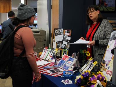 An Alfred State student speaks with a representative from the League of Women Voters during the Douglass Day celebration.