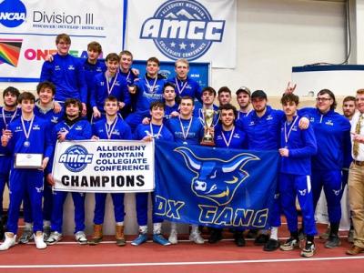 The Alfred State wrestling team poses with the championship trophy and banner after winning the AMCC Championship