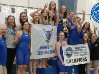 The Alfred State women's swimming and diving team pose on the championship stand after winning the AMCC Championship