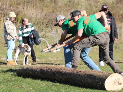 students roll a log at a woodsmen event