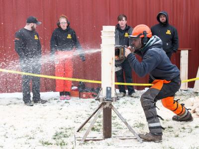 student competes in a timber sports event