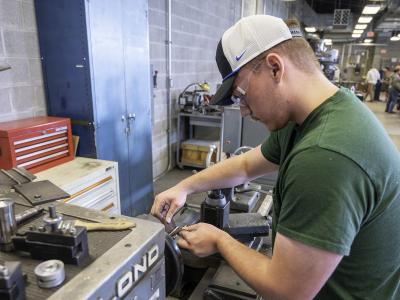 student works on a CNC machine