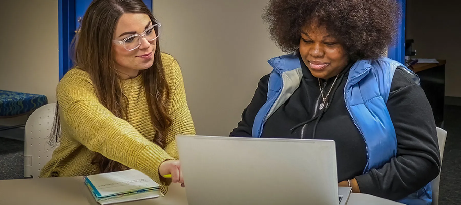 A staff member tutoring a student