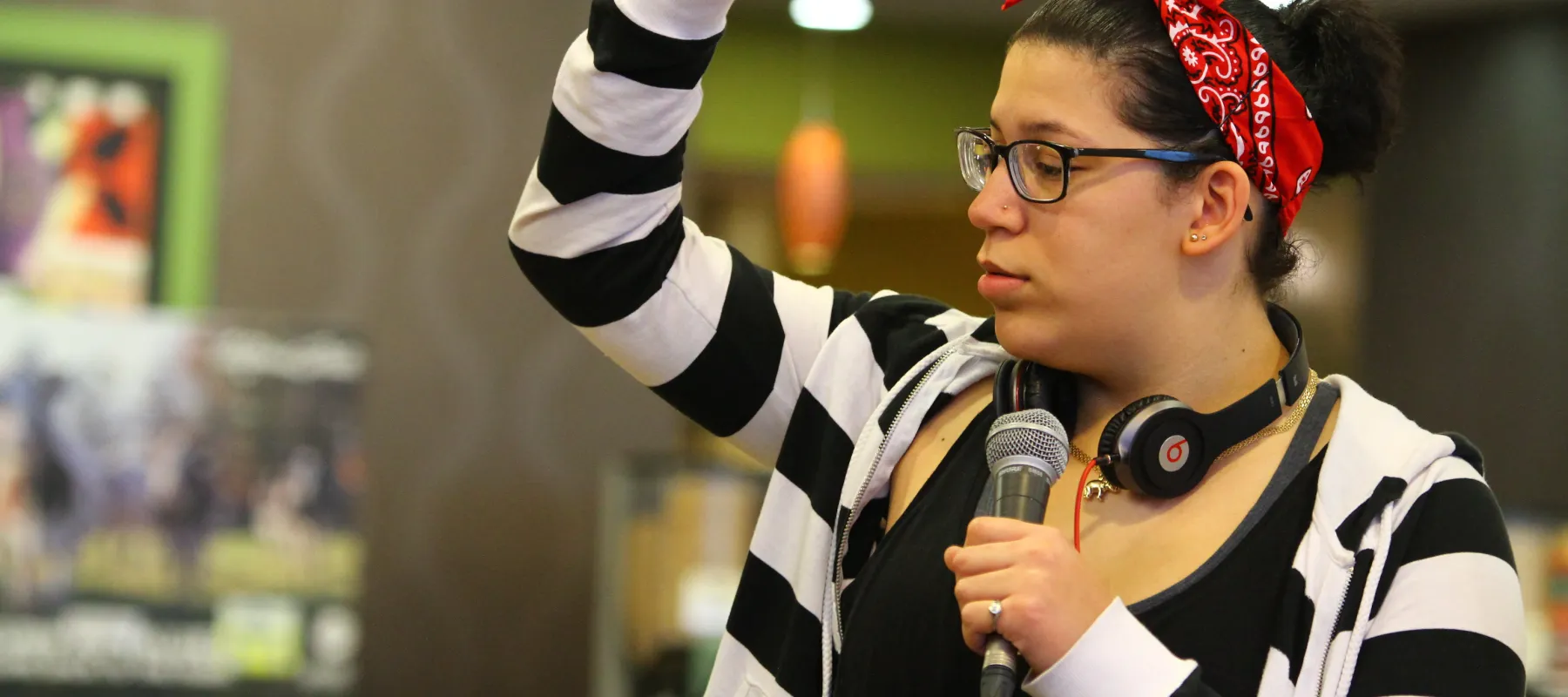 Student standing with microphone at club fair.