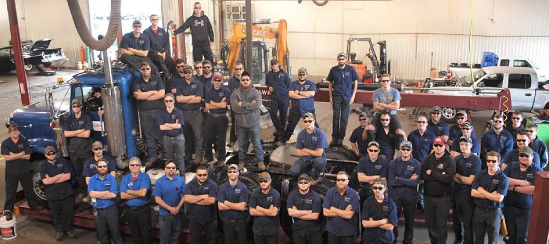 Heavy Equipment, Truck & Diesel Technician students pose for picture on truck.