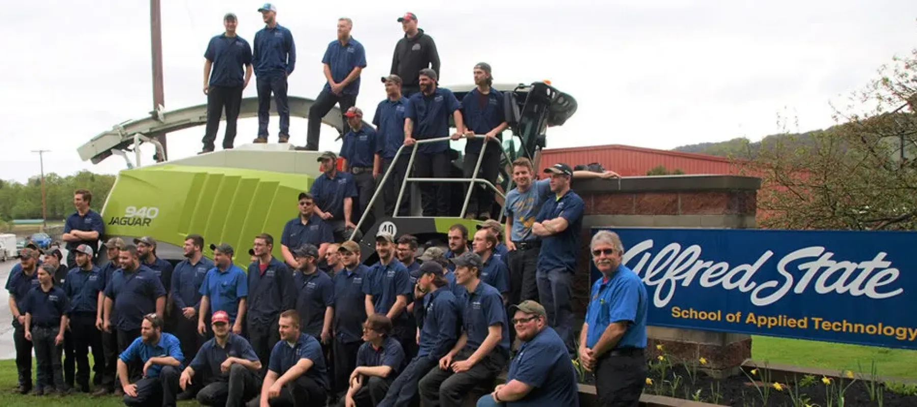 Heavy Equipment, Truck & Diesel Technician students pose for picture outside the main entrance to the Wellsville campus.