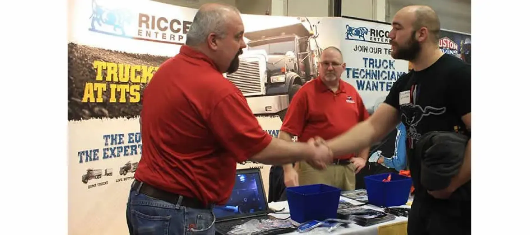 Student shaking hands with representative from Riccelli Enterprises.