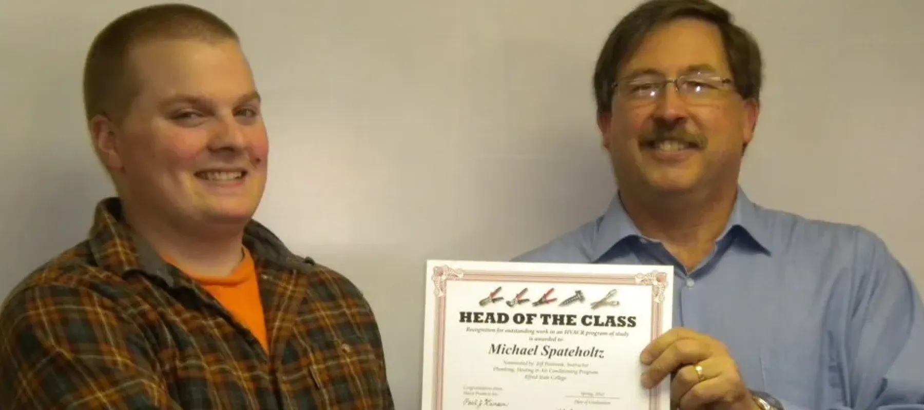Student is presented with Head of the Class award by professor.