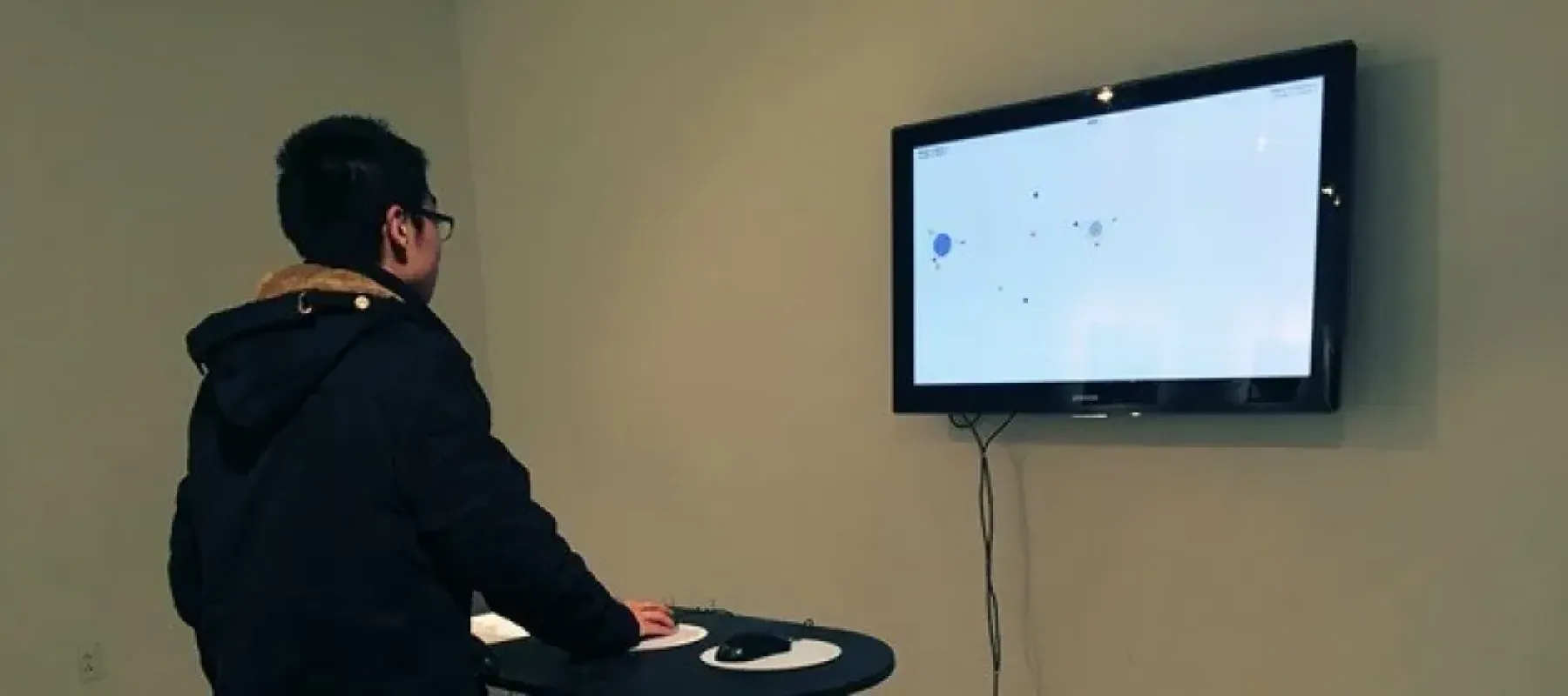 Student interacting the screen on wall.