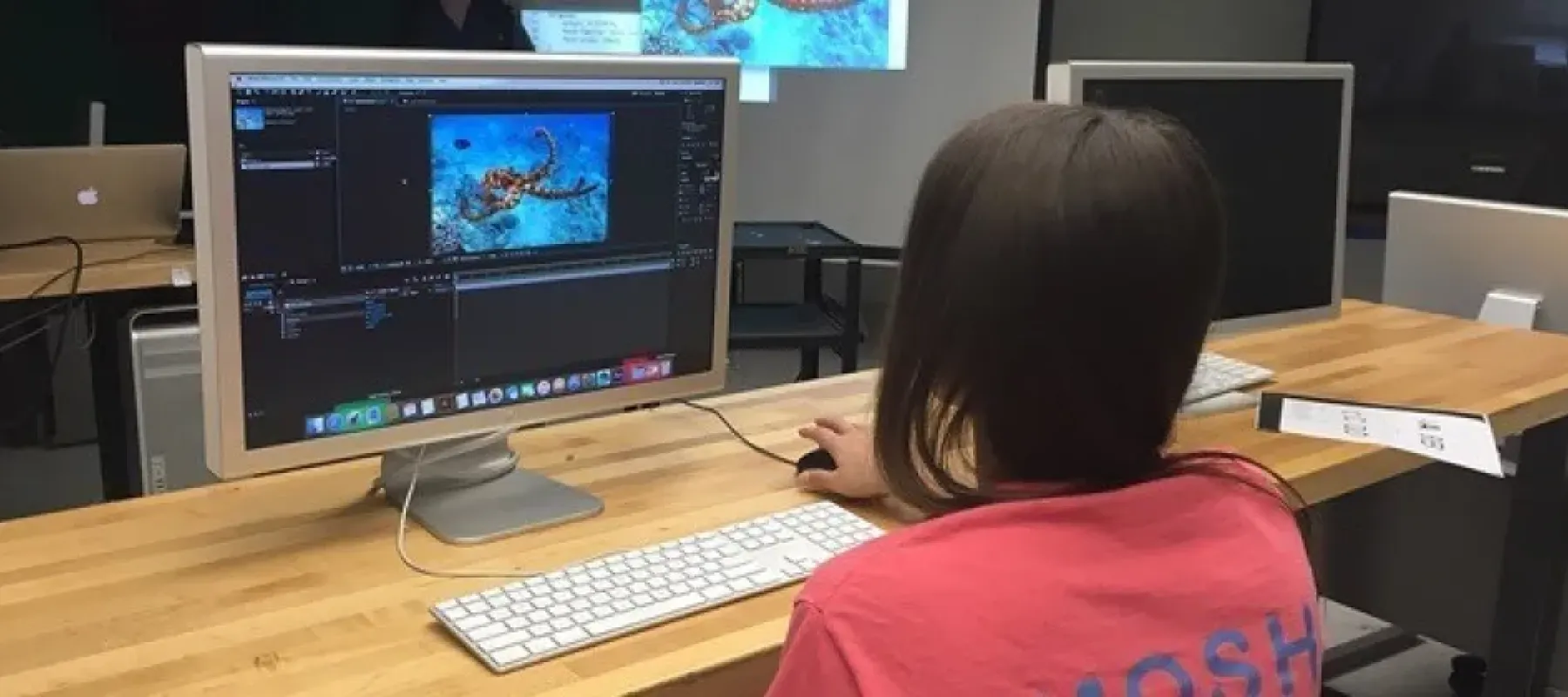 Student working on computer with editing software.