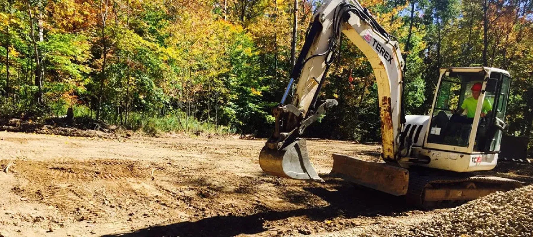 Man inside excavator on work site.