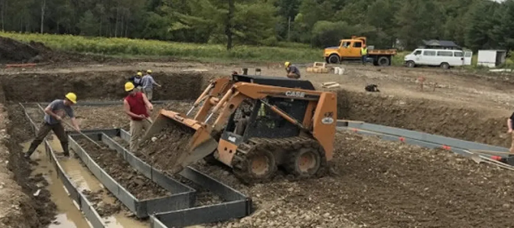 People working outdoors preparing ground for construction.