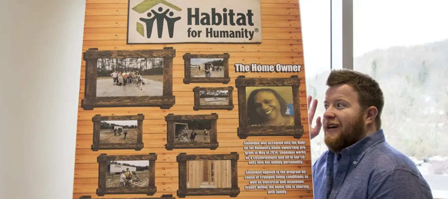 Student showing a sign with information about Habitat for Humanity.