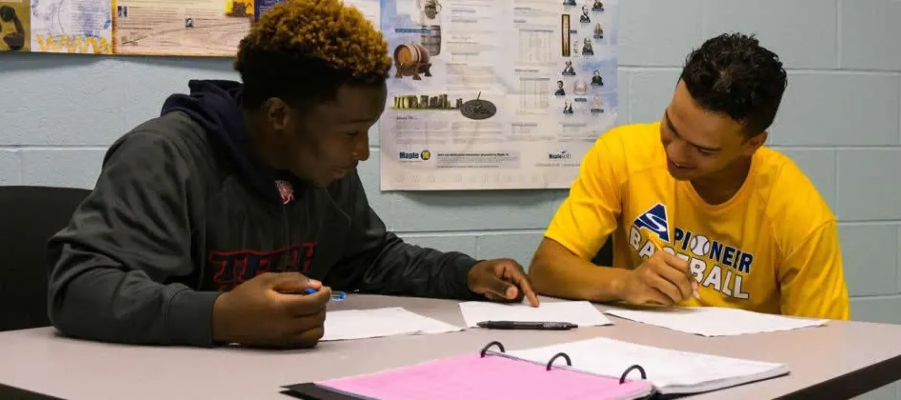 Two students sitting at table working together.