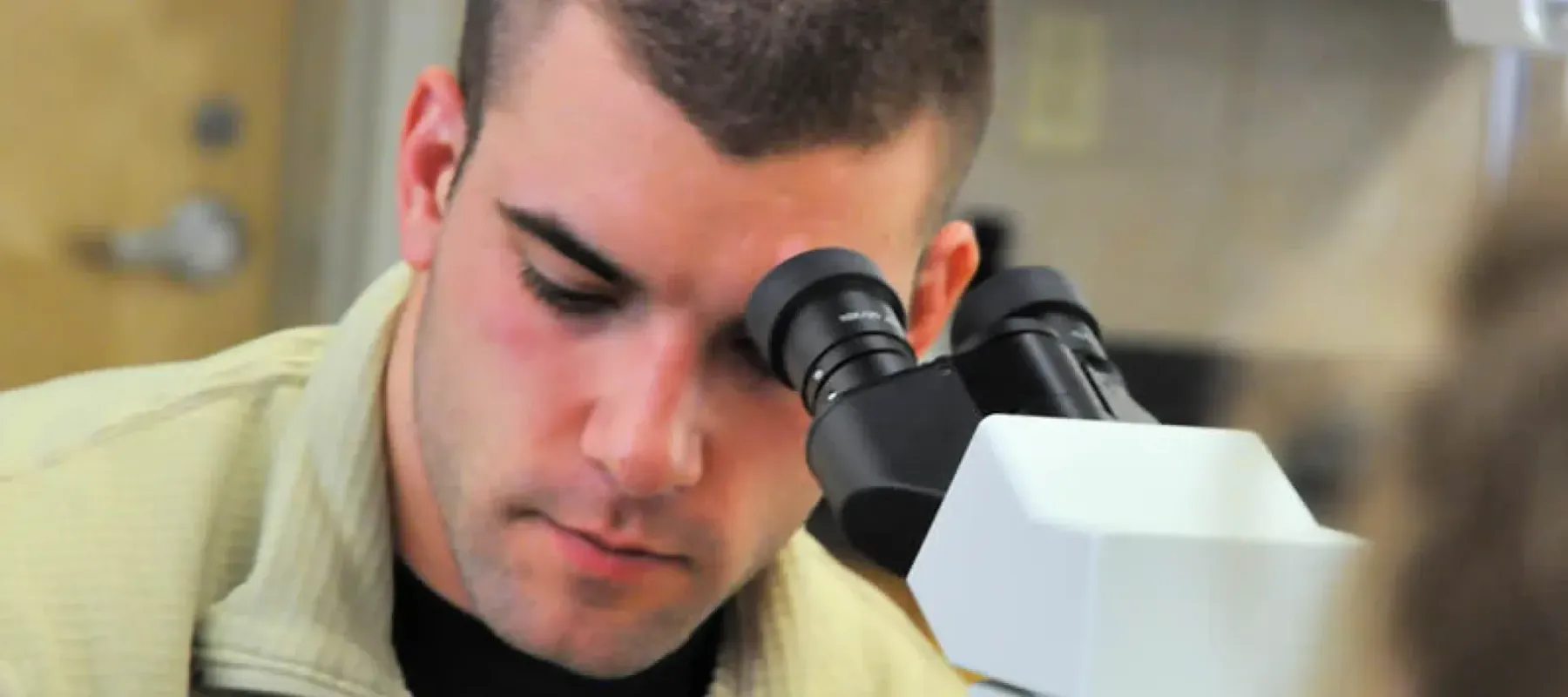 Student looking in microscope.