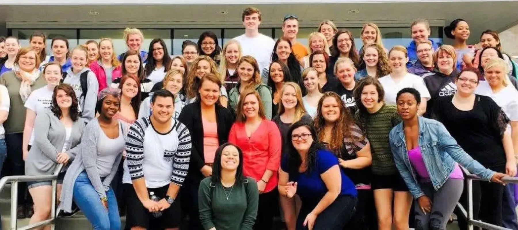 Group of students pose for picture outside on campus.